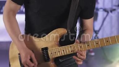 摇滚乐手用彩光在舞台上演奏黄色电吉他